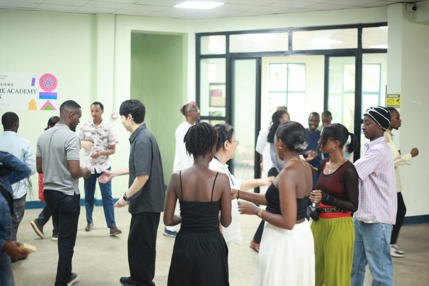 Participants and Sejong Culture Academy team joining hands in a traditional Korean group activity