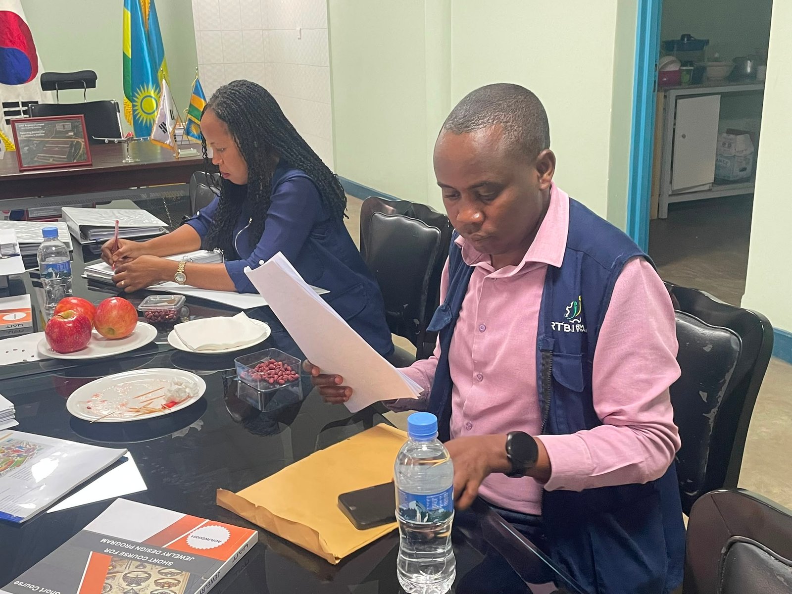 RTB inspector carefully reviewing student portfolio documentation during the CBT/CBA verification at UAIT