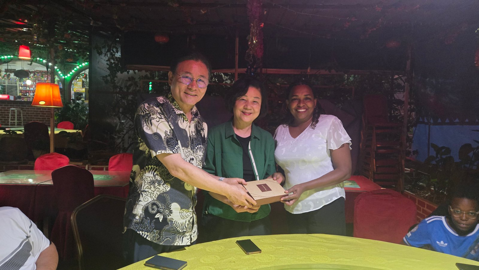 Pastor Ryu Cheol-bae sharing a gift with another UAIT staff family