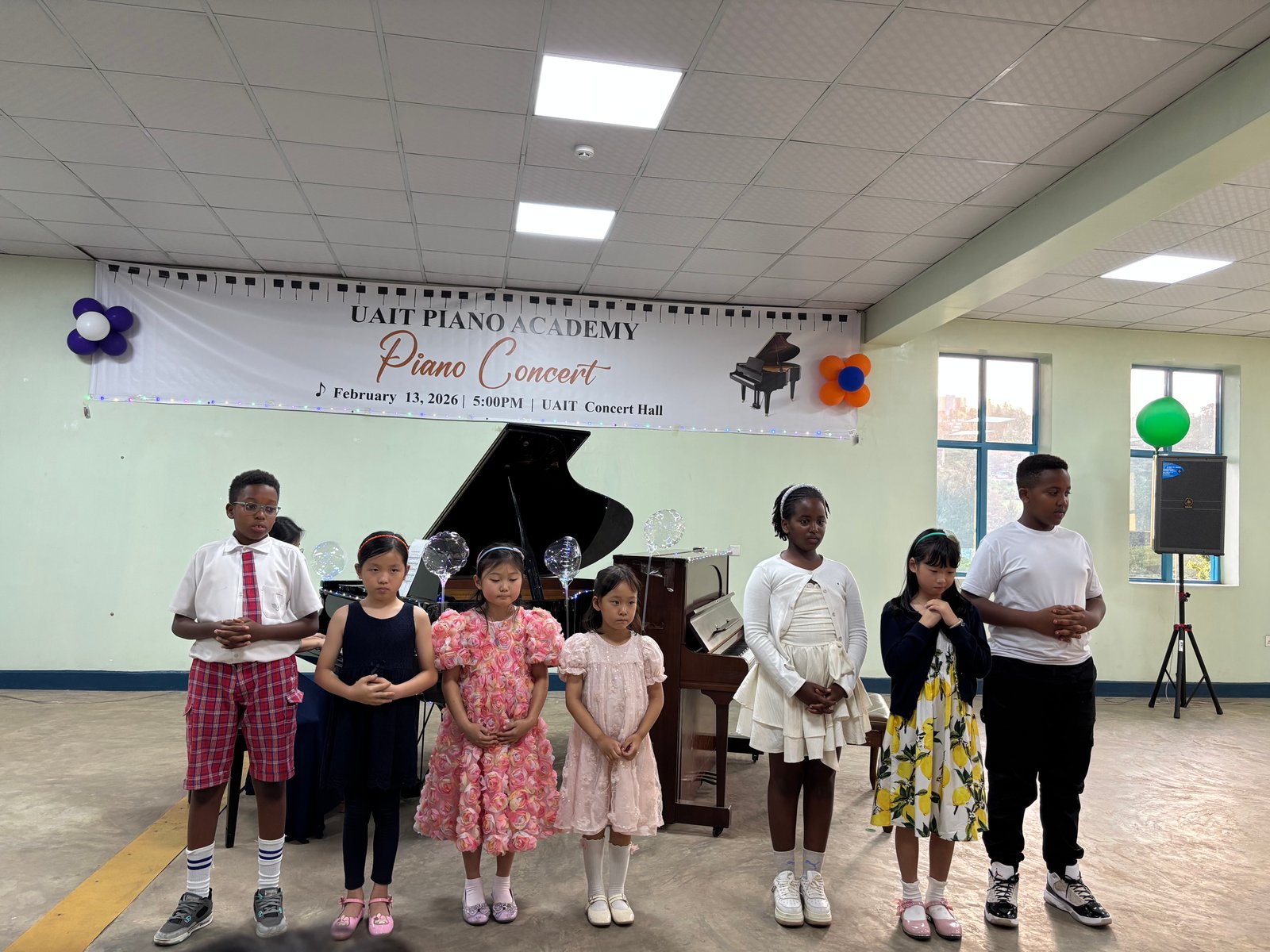 Students standing together on stage after the concert